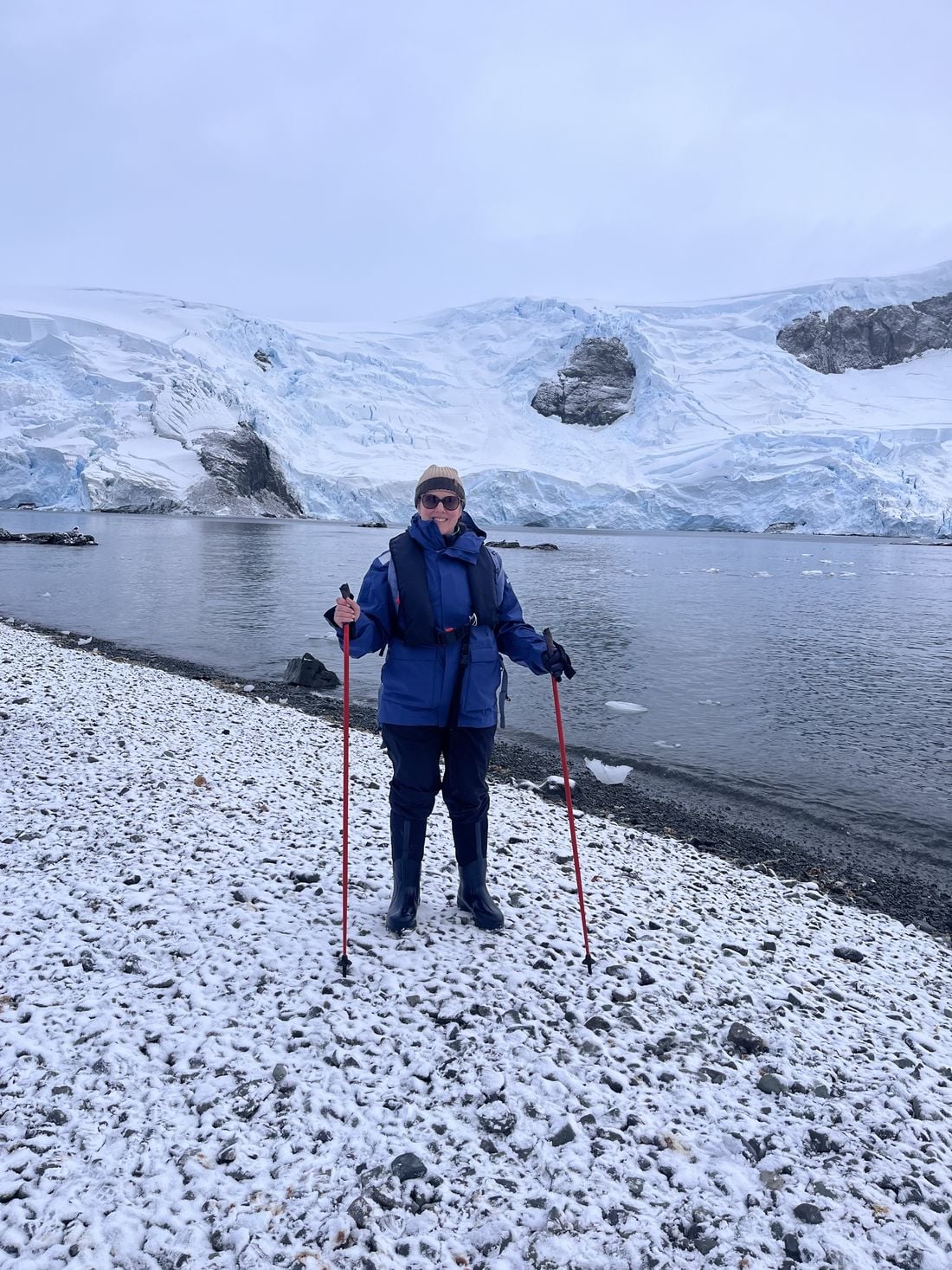 Inspiring Vacations traveller on the shore beneath an Antarctic glacier