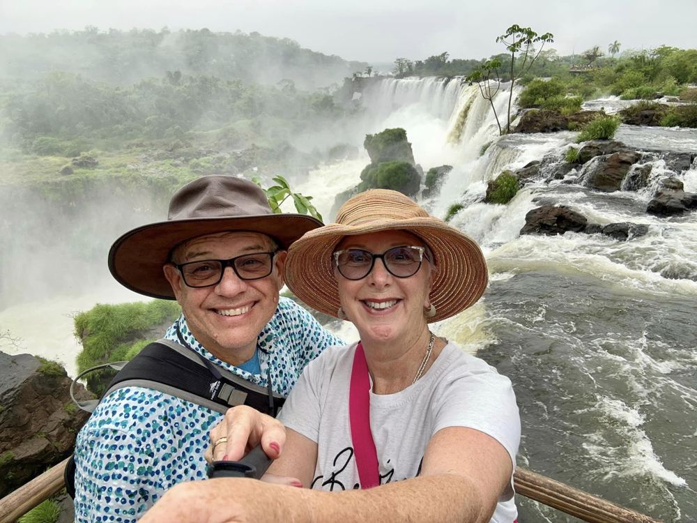 A couple smiling above Iguazu Falls