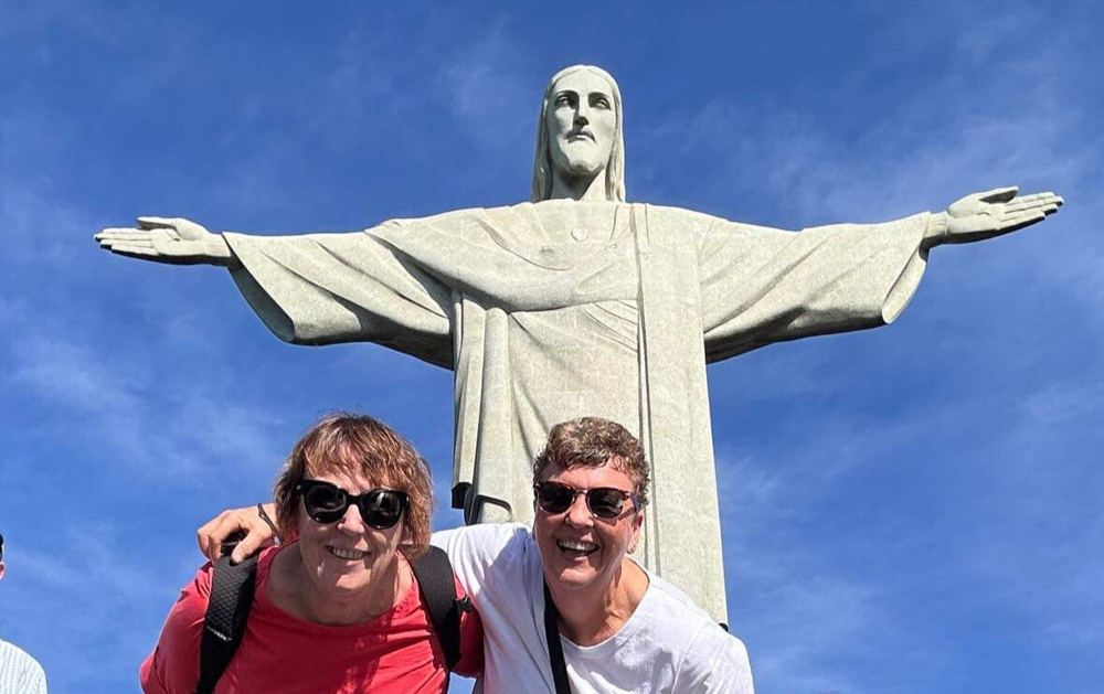 Two travellers beneath Christ the Redeemer in Rio
