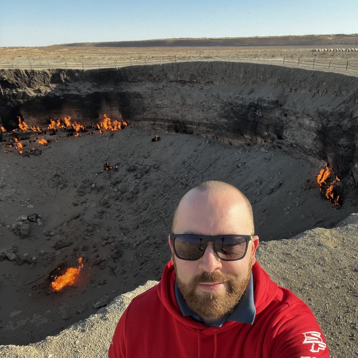 A traveller at the Darvaza Gas Crater at sunrise, Turkmenistan